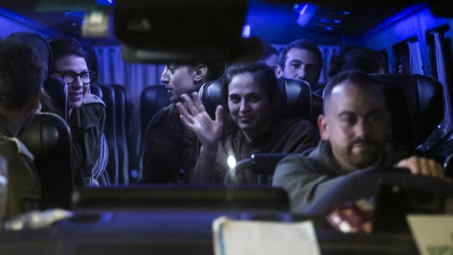 A van carries Israeli hostages released by Hamas from Gaza today, including Yarden Roman-Gat seen waving. Ms Roman-Gat's husband and daughter escaped the October 7 attackers. Picture: Amir Levy/Getty Images