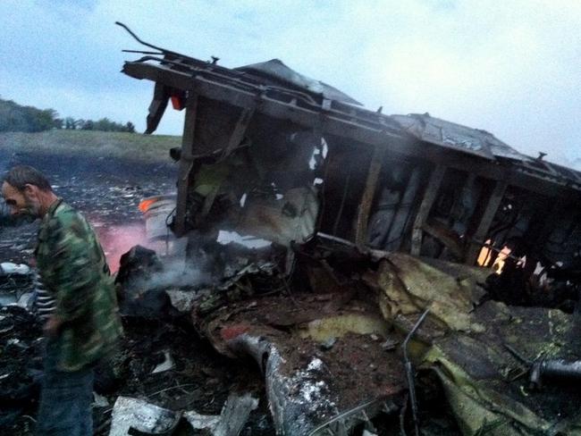 A man stands next to the wreckage of the Malaysian Airlines plane. Picture: AFP / DOMINIQUE FAGET