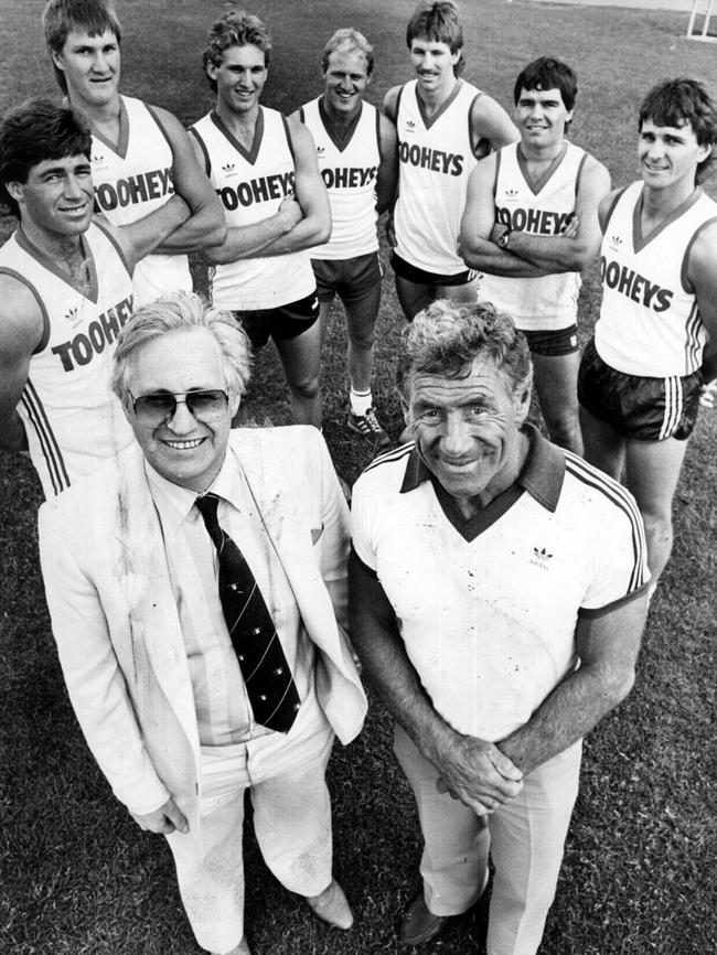 Geoffrey Edelsten with new Sydney Swans coach Tom Hafey. Players Gerard Healy, Tim Barling, Stephen James, David Bolton, Bernard Toohey, Greg Williams and Merv Neagle during first training session for the 1986 season.