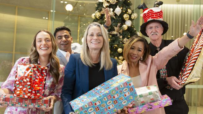 SkyCity MD Avril Baynes (centre) with SkyCity employees Zoe Minuzzo-Larsen,  Keshav Daruka,Queenie Perry and Kym Yeo with presents under their Christmas tree. 4th December 2024. Picture Brett Hartwig