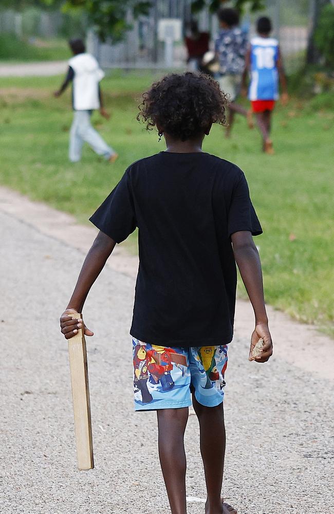 A young boy arms himself with a rock and a length of wood in the Gulf of Carpentaria community. Picture: Brendan Radke