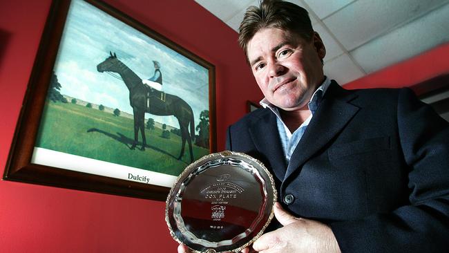 Brent Thomson with a picture of Dulcify and a miniature replica Cox Plate.