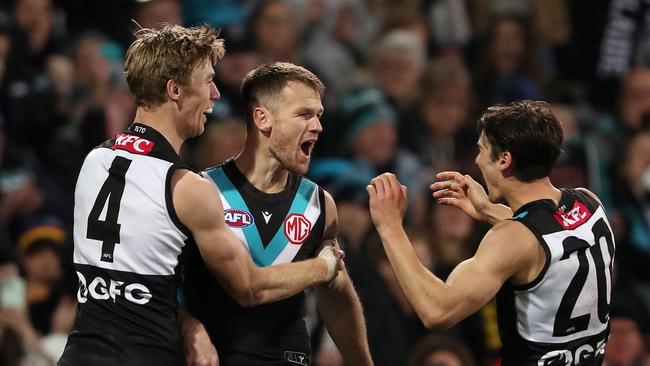 Robbie Gray of the Power celebrates a goal with Todd Marshall and Connor Rozee. Picture: Sarah Reed/AFL Photos