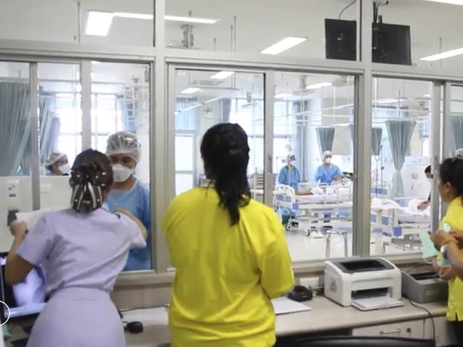 Family members watch the rescued boys through a window outside the recovery ward at the Chiang Rai hospital. Picture: AP