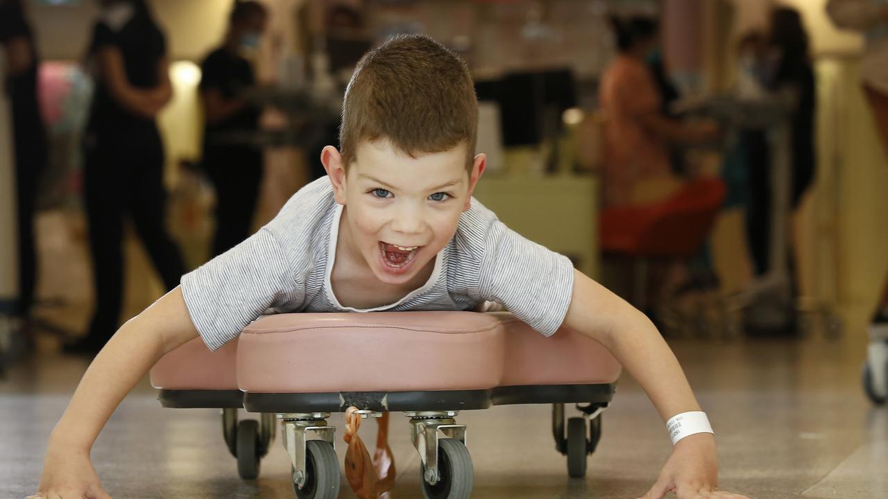 Henry Bryant, four, zooms around the ward on a padded wheel board that helps him with his cerebral palsy. Picture: David Caird