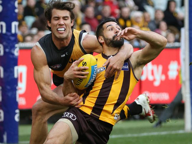 Alex Rance tackles Paul Puopolo around the neck.