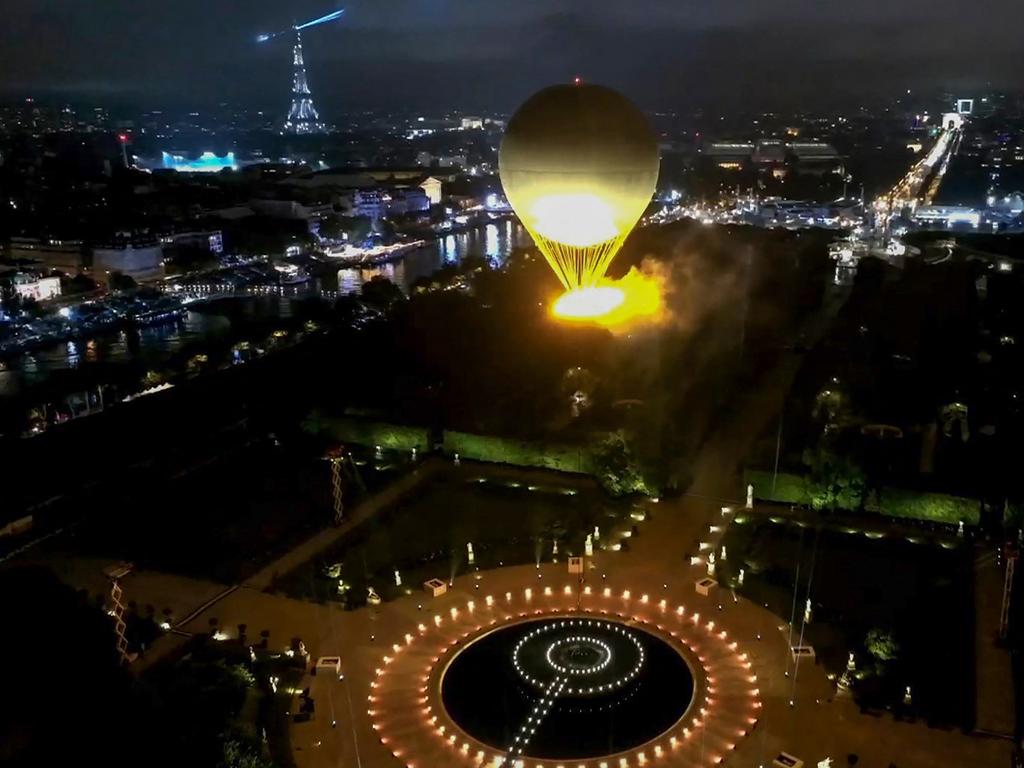 This video grab from the Olympic Broadcasting Services (OBS) shows the cauldron, with the Olympic flame lit, lifts off attached to a balloon during the opening ceremony of the Paris 2024 Olympic Games in Paris on July 26, 2024. (Photo by Olympic Broadcasting Services / AFP) / RESTRICTED TO EDITORIAL USE - MANDATORY CREDIT " OLYMPIC BROADCASTING SERVICES / AFP " - NO MARKETING NO ADVERTISING CAMPAIGNS - DISTRIBUTED AS A SERVICE TO CLIENTS