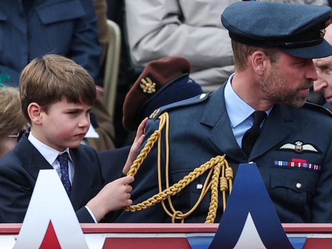 Louis tugged on his dad’s uniform as they took in the event. Picture: Toby Melville - WPA Pool/Getty Images