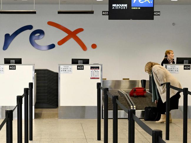 A passenger checks in for a Rex Airlines flight at Melbourne's Tullamarine Airport on July 31, 2024. The Australian regional airline Rex cancelled flights as it entered voluntary administration on July 31, leaving the fate of the country's third-largest carrier in serious doubt. (Photo by William WEST / AFP)