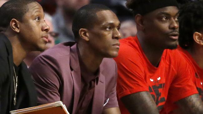 With a cast on his right thumb, Chicago Bulls' Rajon Rondo, centre, sits on the bench.