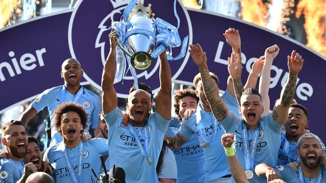 Manchester City's Belgian defender Vincent Kompany (C) lifts the Premier League trophy after their 4-1 victory in the English Premier League football match between Brighton and Hove Albion and Manchester City at the American Express Community Stadium in Brighton, southern England on May 12, 2019. - Manchester City held off a titanic challenge from Liverpool to become the first side in a decade to retain the Premier League on Sunday by coming from behind to beat Brighton 4-1 on Sunday. (Photo by Glyn KIRK / AFP) / RESTRICTED TO EDITORIAL USE. No use with unauthorized audio, video, data, fixture lists, club/league logos or 'live' services. Online in-match use limited to 120 images. An additional 40 images may be used in extra time. No video emulation. Social media in-match use limited to 120 images. An additional 40 images may be used in extra time. No use in betting publications, games or single club/league/player publications. /