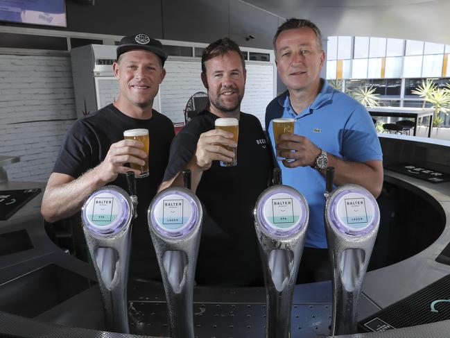 Balter founders Mick Fanning and Ant MacDonald share a glass with Carlton &amp; United Breweries CEO Peter Flipovic at CUB’s Fortitude Valley HQ. Picture: Mark Cranitch