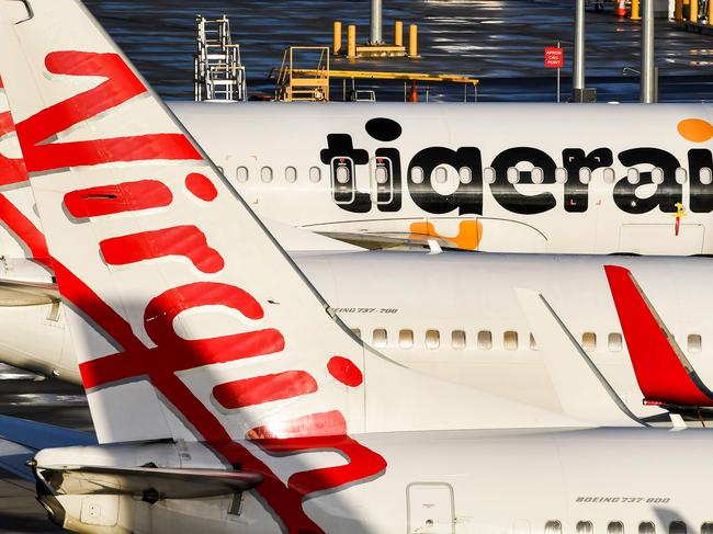 Planes from Australian airlines Tiger Air and Virgin sit idle on the tarmac at Melbourne's Tullamarine Airport on April 12, 2020. - Confinement measures taken around the globe to slow the coronavirus outbreak have forced millions of people to abandon travel plans and stay home, bringing the airline industry to its knees. (Photo by William WEST / AFP)