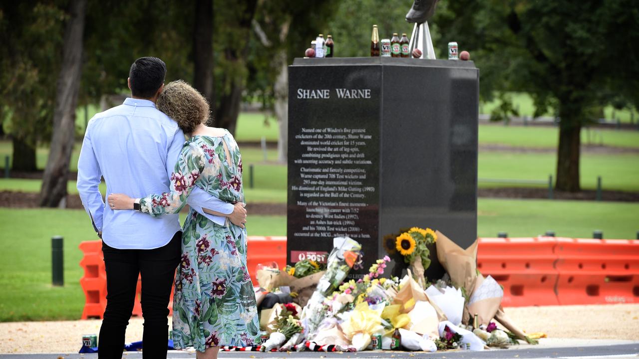 People lay flowers at the statue of Shane Warne at the Melbourne Cricket Ground. Picture: NCA NewsWire / Andrew Henshaw