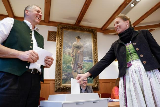 A voter wearing a traditional Bavarian dress casts her ballot in Kochel, southern Germany