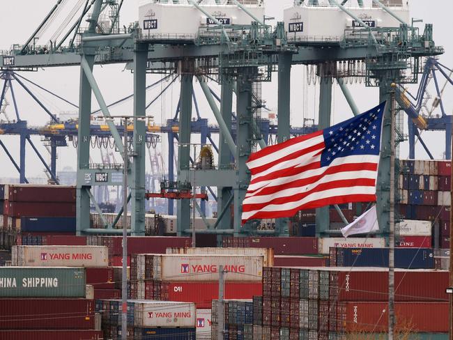 Chinese shipping containers are stored beside a US flag after they were unloaded at the Port of Los Angeles in Long Beach, California on May 14, 2019. - Global markets remain on red alert over a trade war between the two superpowers China and the US, that most observers warn could shatter global economic growth, and hurt demand for commodities like oil. (Photo by Mark RALSTON / AFP)