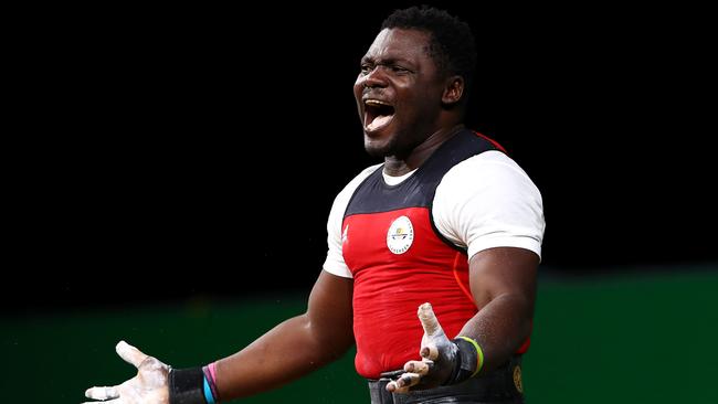 Petit David Minkoumba of Cameroon celebrates during the men's 94kg weightlifting final. Picture: Getty