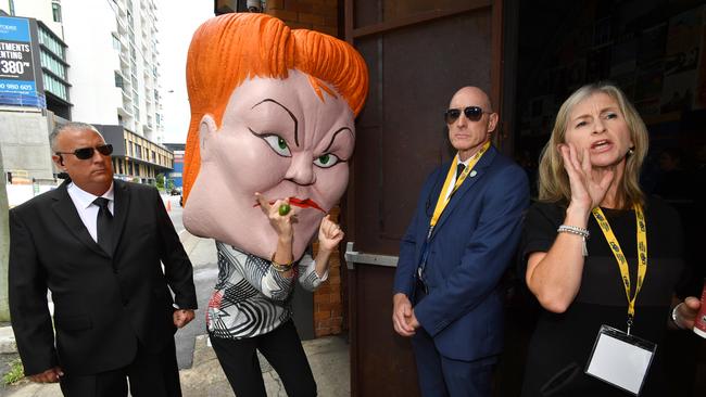 A protester wearing a mask depicting Pauline Hanson is seen outside the LNP campaign launch at The Triffid in Brisbane. Picture: AAP/Darren England