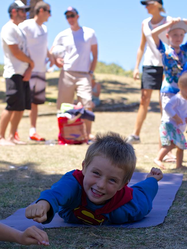 Superman does the Superman pose at a yoga birthday party.