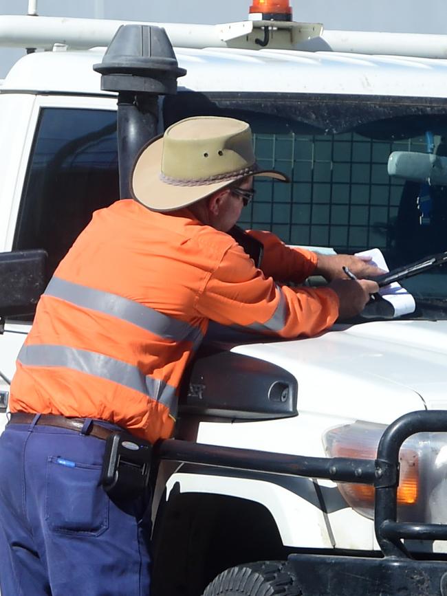 A Townsville City Council parking inspector issues a ticket in the CBD.