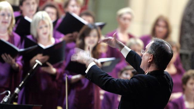 Queensland Choir chorus master Kevin Power leads choristers.