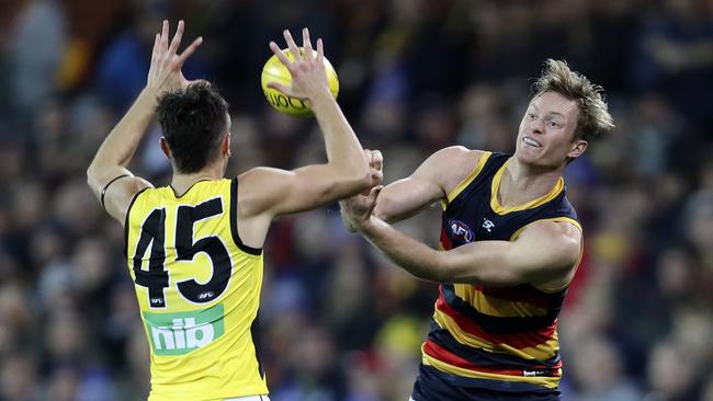 Adelaide’s Alex Keath handballs over Richmond’s Patrick Naish. Picture: Sarah Reed