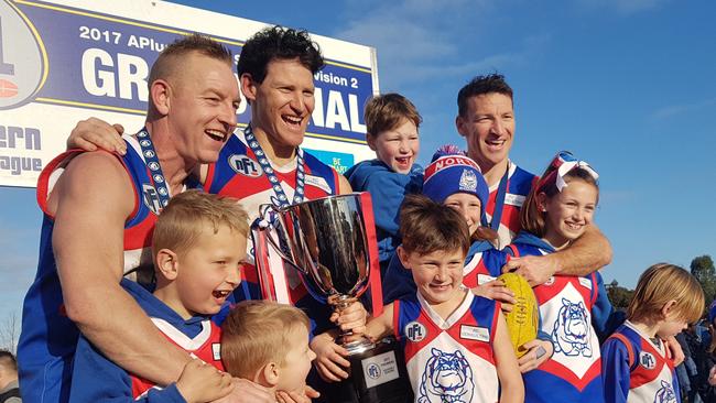 Blair, Shane and Brent Harvey celebrate North Heidelberg's 2017 NFL premiership with their children.