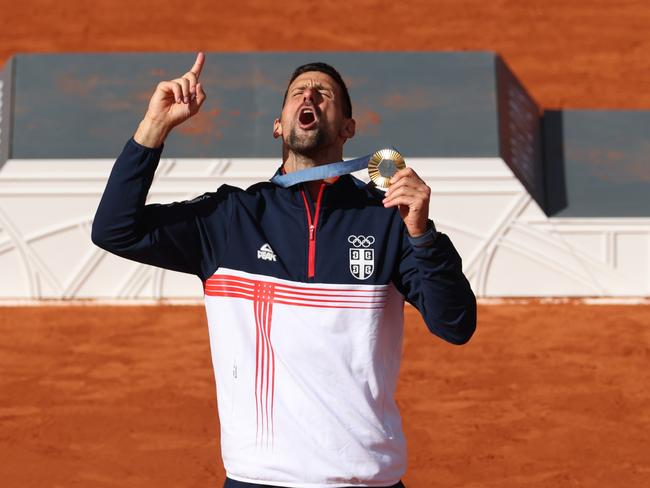 PARIS, FRANCE - AUGUST 04: Gold medallist Novak Djokovic of Team Serbia celebrates during the Tennis Men's Singles medal ceremony after the Tennis Men's Singles Gold medal match on day nine of the Olympic Games Paris 2024 at Roland Garros on August 04, 2024 in Paris, France. (Photo by Matthew Stockman/Getty Images)