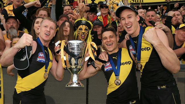 Tom Lynch (right) with ex-Gold Coast teammates Josh Caddy and Dion Prestia and the premiership cup. Picture: Mark Stewart