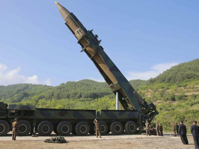 North Korean leader Kim Jong-un, second from right, pictured before the launch of a Hwasong-14 intercontinental ballistic missile in July as he smoked a cigarette nearby. Picture: KCNA/Korea News Service/AP