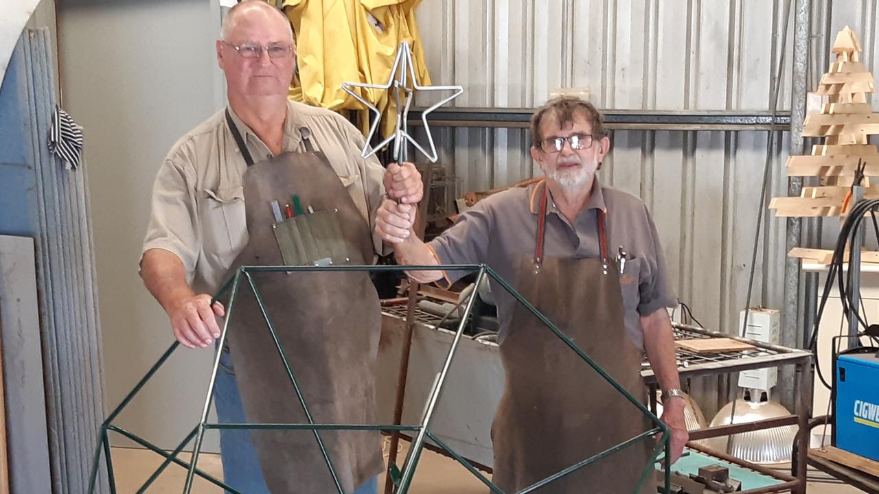 Oakey Men's Shed members John Harrison (left) and Leon Batzloff roll another Christmas tree off the production line.