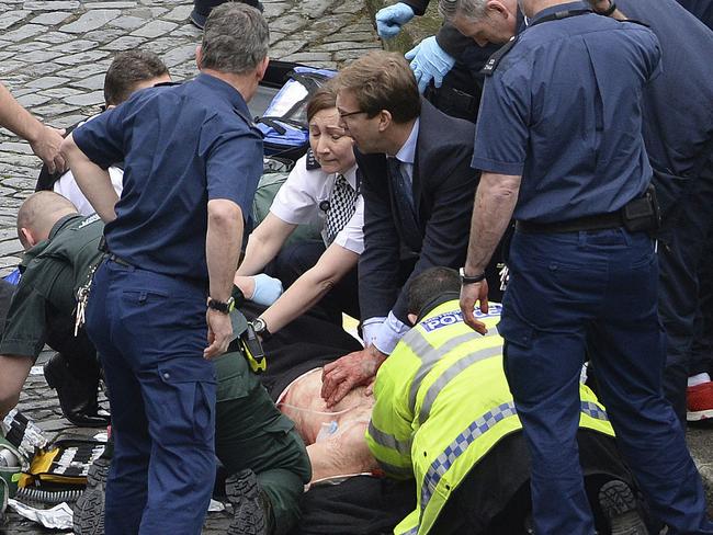 Conservative Member of Parliament Tobias Ellwood, centre, helps emergency services attend to an injured person outside the Houses of Parliament, London, Wednesday, March 22, 2017. Picture: Stefan Rousseau/PA via AP