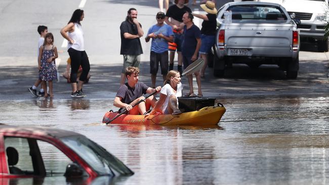 Residents using a kayak to gain access to their flooded home in Graceville Ave, Graceville. Picture: Liam Kidston