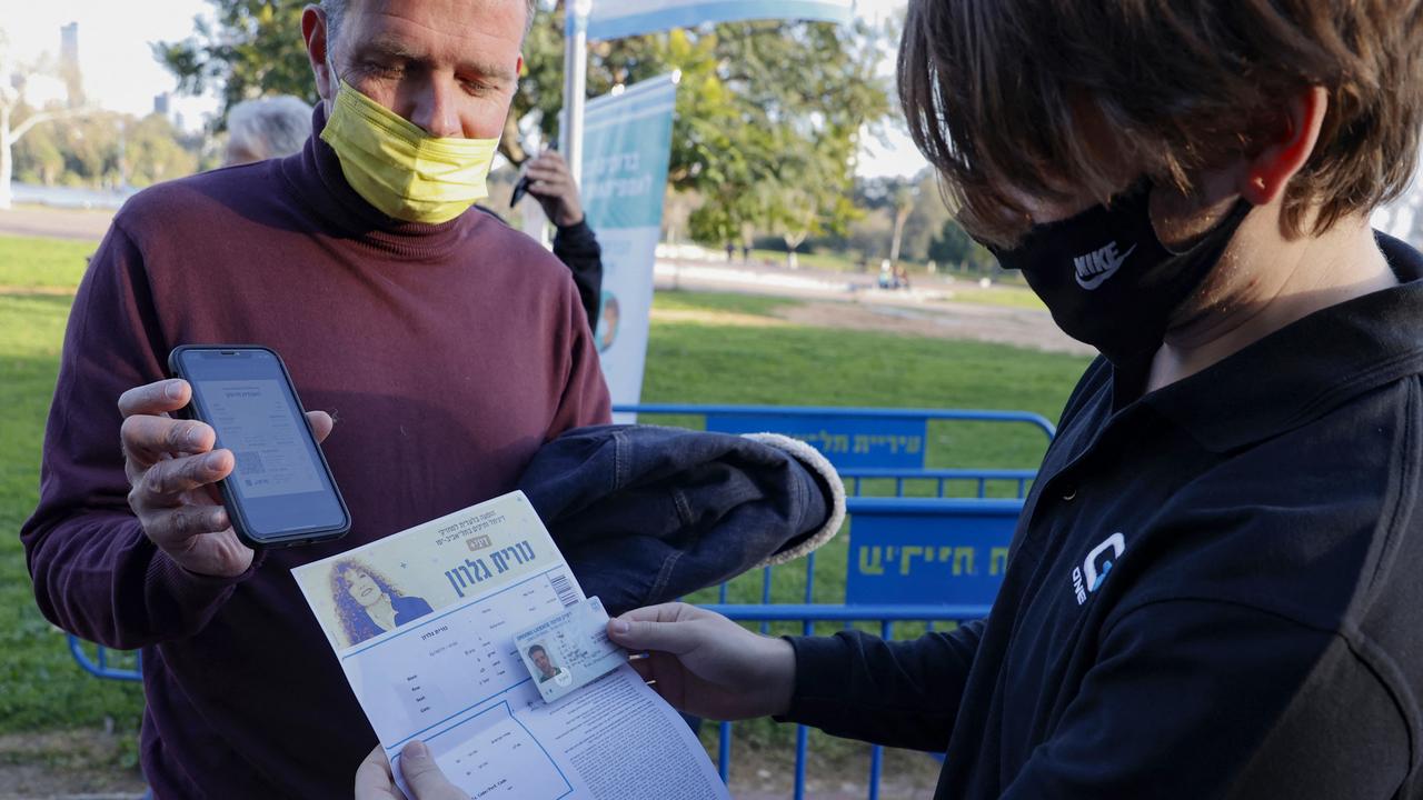 An Israeli man shows his ‘green pass’ (proof of being fully vaccinated against Covid) as the UK announces it’s scrapped plans for a vaccination passport in England. Picture: Jack Guez/AFP