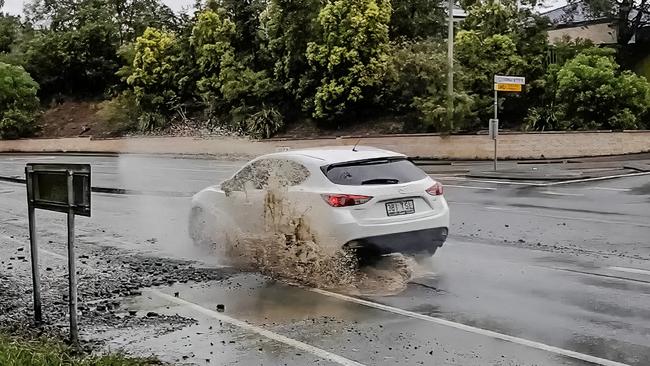 A car runs through the pothole. Picture: Luke Sorensen