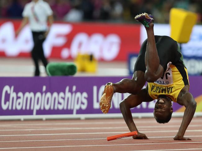 The Jamaican superstar uses a barrel roll to break his fall. Picture: AFP