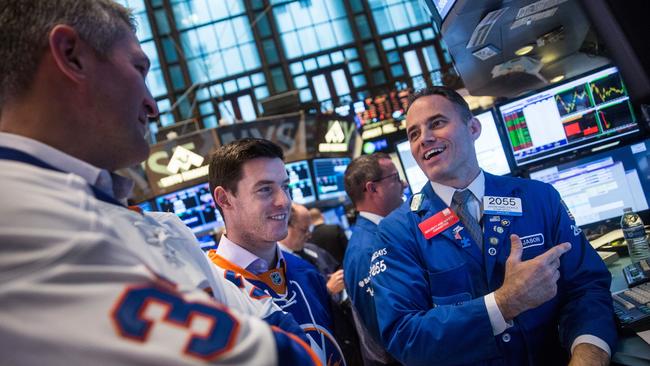 NEW YORK, NY - OCTOBER 08: Retired professional hockey player Eric Cairns (L) and professional hockey player Thomas Hickey talk to a trader on the floor of the New York Stock Exchange after helping ring the opening bell on October 8, 2015 in New York City. Various members of the National Hockey League helped ring this morning's opening bell. Andrew Burton/Getty Images/AFP == FOR NEWSPAPERS, INTERNET, TELCOS & TELEVISION USE ONLY ==