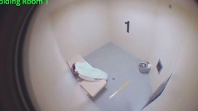 A screen grab from the arrest of Tanya Day as she lies under a blanket in a police cell. Supplied