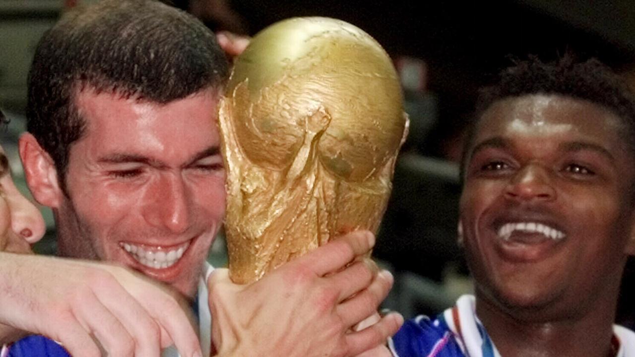 Player Zinedine Zidane (c) holding trophy celebrating with Marcel Desailly (r) and teammates after win. Soccer — France vs. Brazil World Cup final match at Stade De France in Saint-Denis 12 Jul. 1998