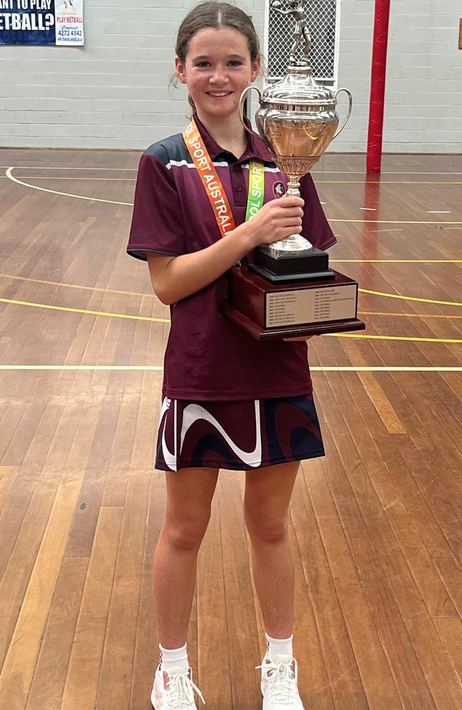 Sunshine Coast netball player Summer Hassell holds the trophy after representing Queensland at the Australian Championships.