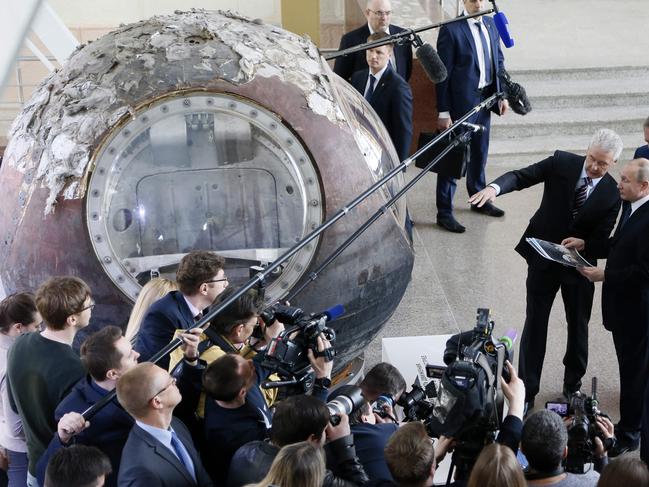 Moscow Mayor Sergei Sobyanin (front L) gestures as Russian President Vladimir Putin (front C), State Space Corporation ROSCOSMOS Director General Igor Komarov (front R) and Russian Deputy Prime Minister and Head of ROSCOSMOS Supervisory committee, Dmitry Rogozin (back) as they visit the reconstructed historical 'Space' pavilion at the VDNH (Exhibition of Achievements of National Economy) multifunctional exhibition centre in Moscow, on April 12, 2018. Russia marks the Cosmonautics Day on 12 April. / AFP PHOTO / POOL / Maxim SHIPENKOV