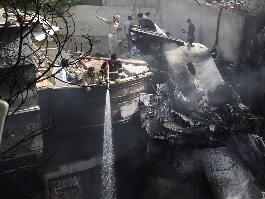 Firefighters spray water on the wreckage of a Pakistan International Airlines aircraft after it crashed at a residential area in Karachi. Picture: AFP