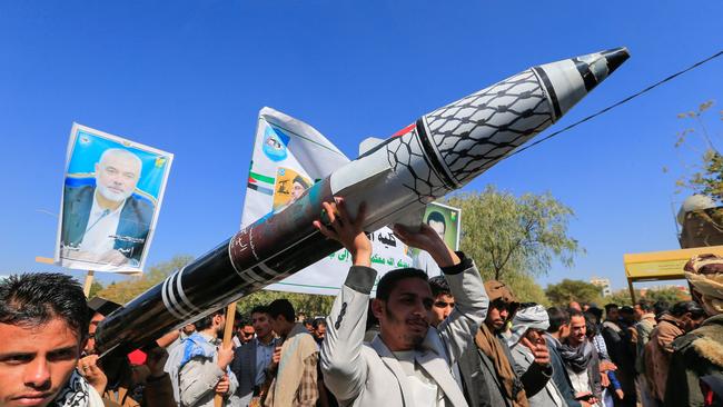 Men carry a mock missile during a rally by university students and faculty denouncing strikes on Yemen. Picture: AFP