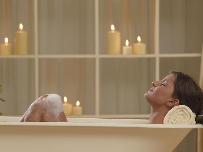 Woman in bathtub with candles.