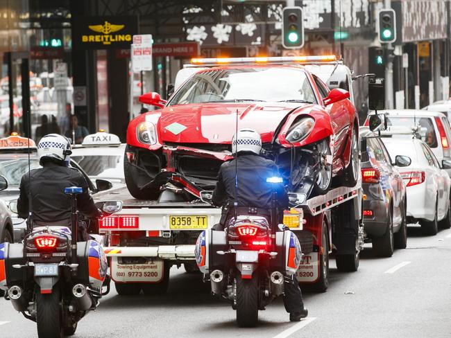 Police escort the tow truck through the city. Picture: Tim Pascoe