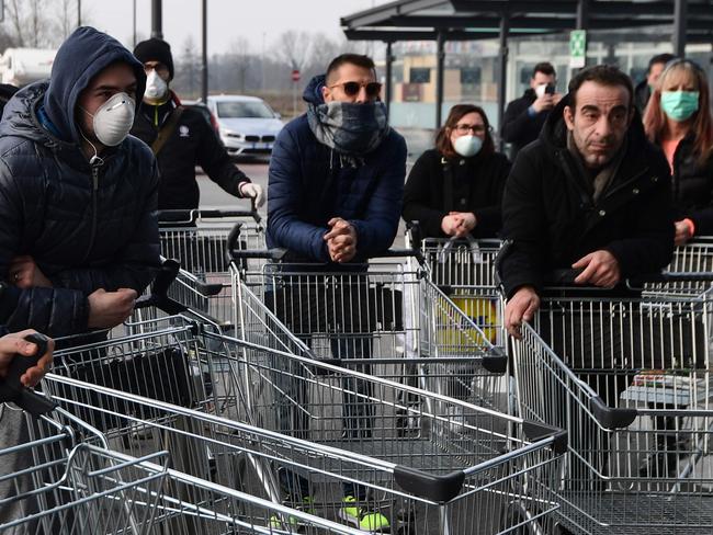 TOPSHOT - Residents wait to be given access to shop in a supermarket in small groups of forty people on February 23, 2020 in the small Italian town of Casalpusterlengo, under the shadow of a new coronavirus outbreak, as Italy took drastic containment steps as worldwide fears over the epidemic spiralled. (Photo by Miguel MEDINA / AFP)