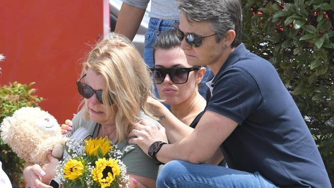 Libby Ruge's mum Julie Ruge (left), her older sister Stevie Shanahan and mum Julie Harrison (right) lay flowers on Flinders Street on Thursday. Picture: NCA NewsWire / Simon Bullard
