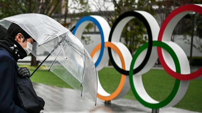 A man walks past the Olympic rings outside the Japan Olympic Museum in Tokyo. Picture: AFP