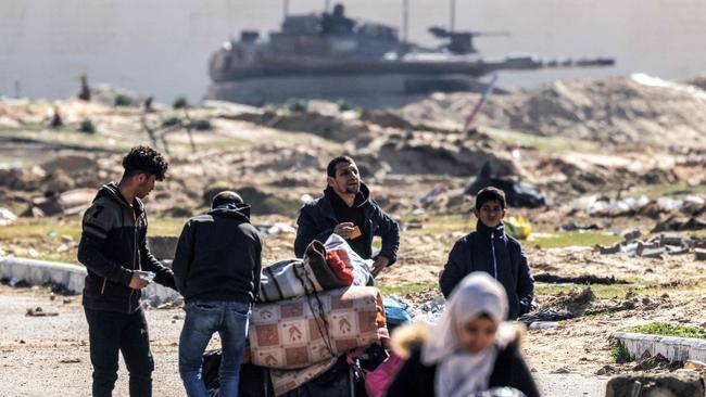 An Israeli battle tank is deployed to guard a position as displaced Palestinians flee from Khan Younis. Picture: AFP