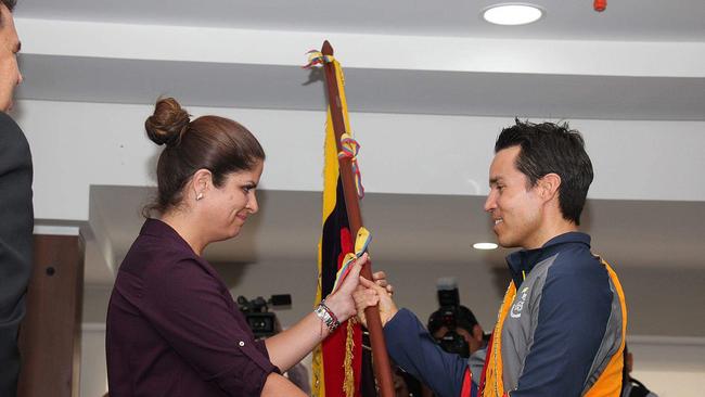 Klaus Jungbluth Rodriguez (right) being presented with the Ecuadorean flag by a Ministry of Sports representative..